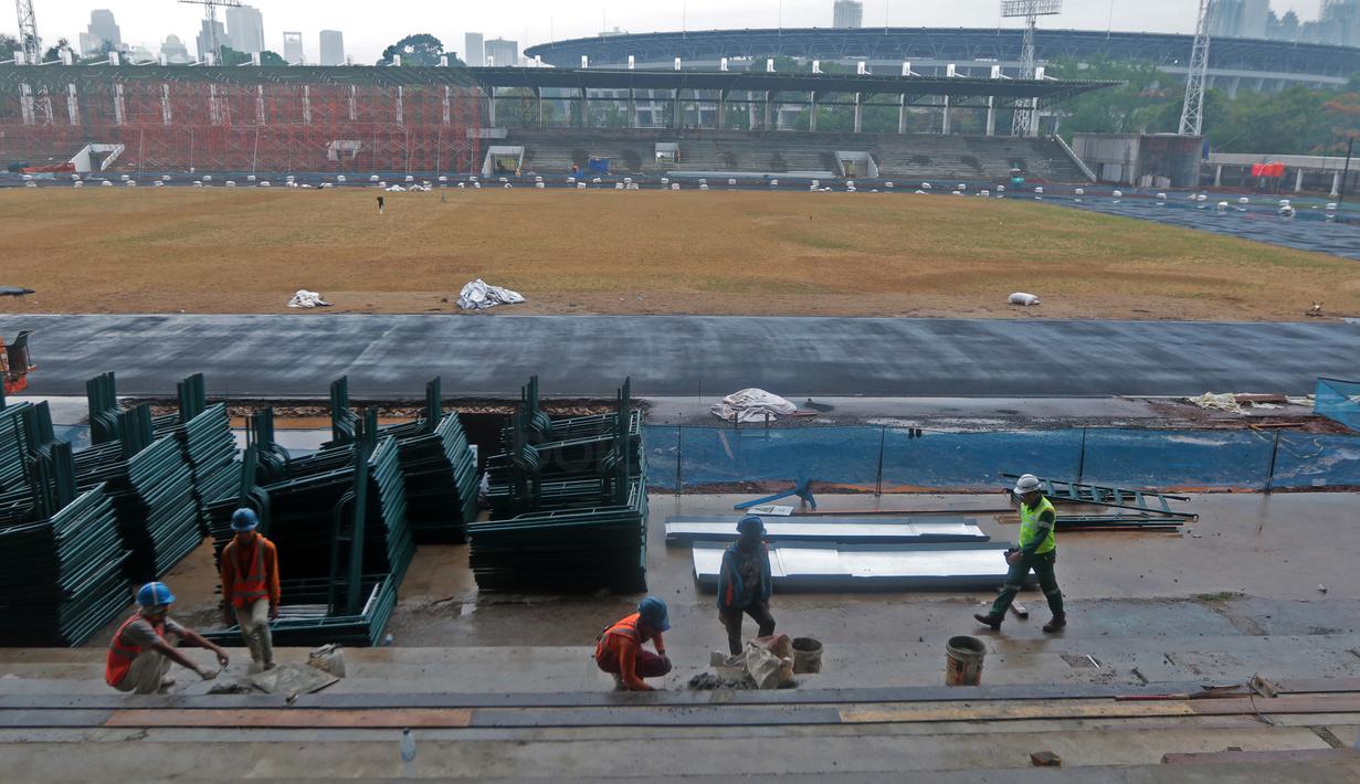 Pekerja sedang melakukan renovasi tribun venue Atletik Stadion Madya di Kawasan Senayan Sport Center, Jakarta (12/10/2017). Renovasi stadion tersebut untuk menyambut Asian Games 2018. (Bola.com/Nicklas Hanoatubun)