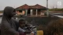 Warga melintasi rumah rusak yang ditinggalkan penghuni di Kampung Beting. Kini warga hanya bisa pasrah dengan kelanjutan dampak abrasi yang akan terjadi dan berharap pemerintah Kabupaten Bekasi sadar dan segera mengatasi langgengnya abrasi di pesisir utara Bekasi itu. (merdeka.com/Iqbal S Nugroho)