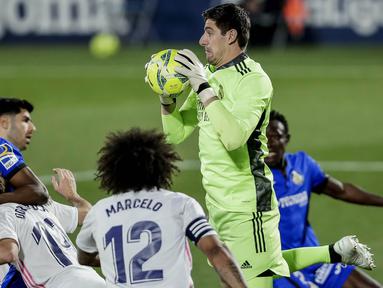 Kiper Real Madrid, Thibaut Courtois, menangkap bola saat melawan Getafe pada laga Liga Spanyol di Stadion Alfonso Perez, Senin (19/4/2021). Kedua tim bermain imbang 0-0. (AP Photo/Manu Fernandez)
