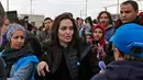 <p>Utusan khusus lembaga pengungsi PBB, aktris Angelina Jolie menyapa warga saat mengunjungi Kamp Pengungsi Suriah Zaatari di Mafraq, Yordania, Minggu (28/1). Jolie turut mengajak dua buah hatinya, Zahara (13) dan Shiloh (11). (Khalil MAZRAAWI/AFP)</p>