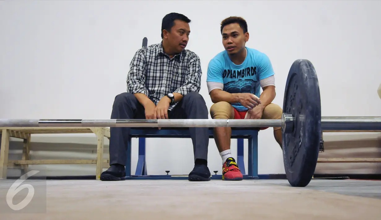 Menpora Imam Nahrawi (kiri) berbincang dengan Eko Yuli Irawan saat meninjau kesiapan akhir atlet angkat besi di PB PABBSI, Jakarta, Selasa (21/6). Tujuh atlet angkat besi akan berlaga di Olimpiade Rio 2016. (Liputan6.com/Helmi Fithriansyah)