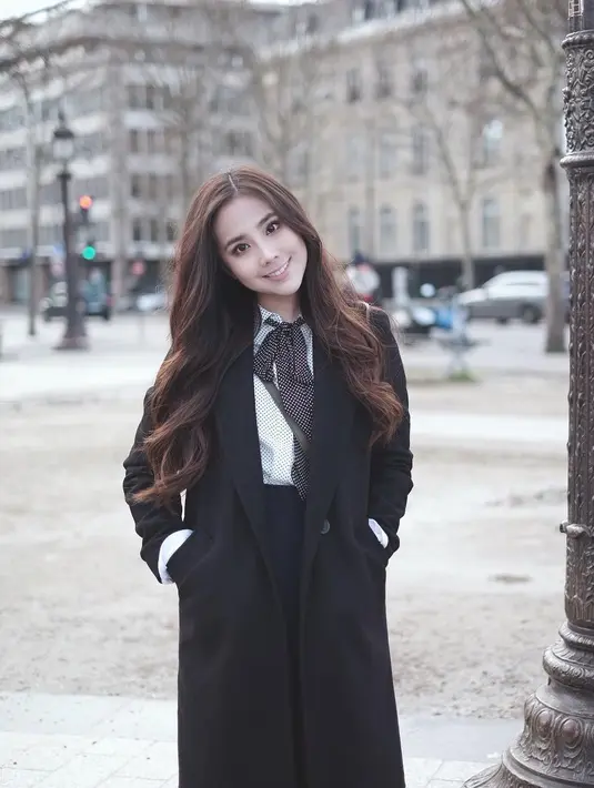 Rambut tebal nan panjang, serta mata belo yang dimiliki gadis berkulit putih ini kerap mengenakan baju ala-ala gaya Korea. Memakai long coat dengan dalaman kemeja putih berdasi. (Instagram/agatha_chelsea)