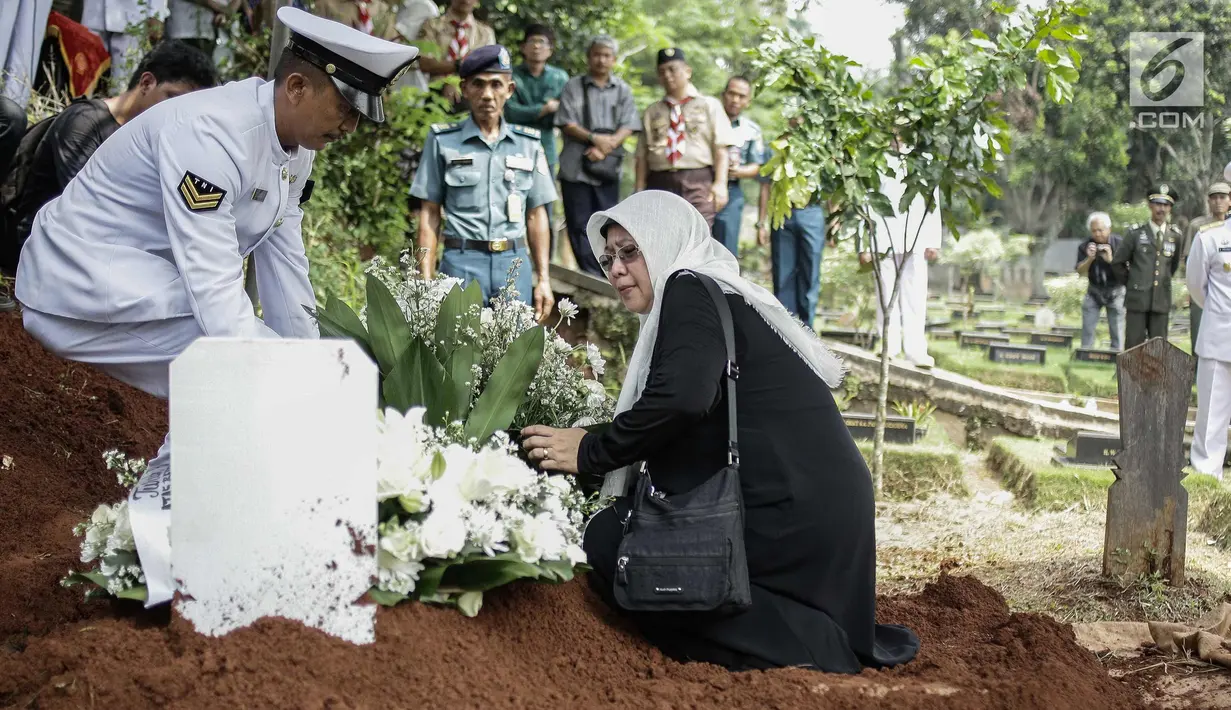 Keluarga dan kerabat menaruh bunga di makam almarhum Amoroso Katamsi di (TPU) Tanah Wakaf Pondok Labu, Jakarta, Selasa (17/4). Amoroso meninggal pada Selasa 17 April 2018 pukul 01.40 dini hari pada usia 79 tahun. (Liputan6.com/Faizal Fanani)
