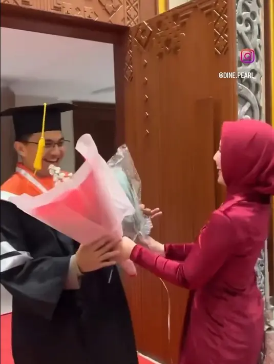 Berikut potret bahagia wisuda didampingi istri Dine Mutiara. Sang istri yang mendampingi memberikan dua bunga untuk sang suami yang masih mengenakan toga. [Instagram/dine.pearl]
