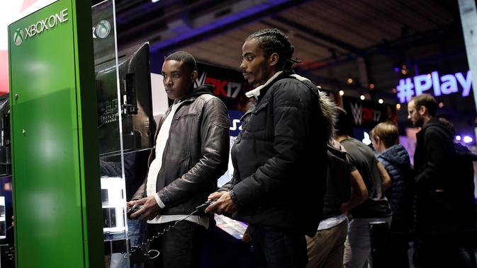 Dua pengunjung serius bermain Xbox One pada acara Paris Games Week di Paris, Prancis (26/10). Paris Games Week diselenggarkan pada 27–31 October. (REUTERS/Benoit Tessier)