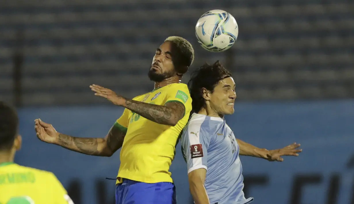 Gelandang Brasil, Douglas Luiz berebut bola udara dengan penyerang Uruguay, Edinson Cavani pada pertandingan keempat kualifikasi Piala Dunia 2022 zona CONMEBOL di Estadio Centenario, Montevideo, Selasa (17/11/2020). Brasil menang atas Uruguay 2-0. (Raul Martinez / Pool via AP)