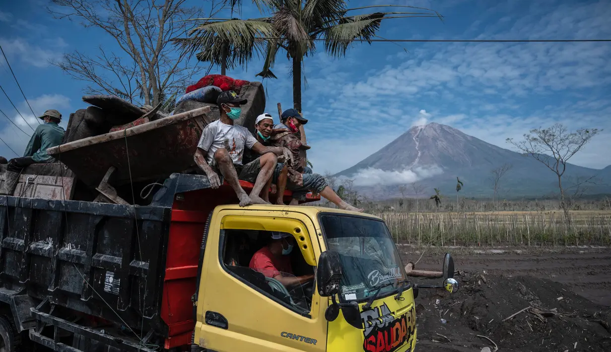 Warga mengevakuasi barang-barang mereka menggunakan truk dari rumahnya yang rusak akibat erupsi Gunung Semeru di desa Curah Kobokan di Lumajang, Jawa Timur, Rabu (8/12/2021). Korban meninggal akibat erupsi Gunung Semeru bertambah menjadi 35 orang hingga Rabu pagi. (Juni Kriswanto / AFP)