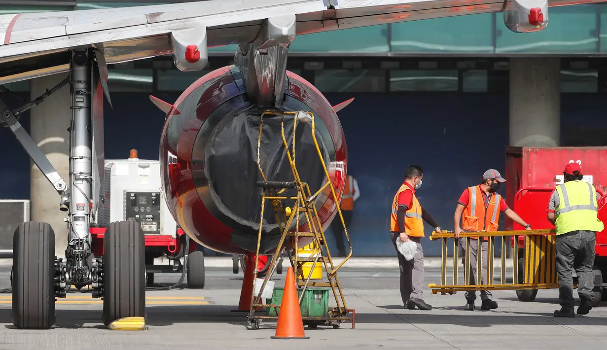 Sebuah motor pesawat dilapisi plastik agar abu vulkanik tidak masuk di bandara internasional La Aurora yang telah ditutup akibat erupsi di gunung berapi Pacaya di Guatemala City (23/3/2021). (AP Photo / Moises Castillo )