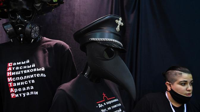 Seorang peserta menata barang-barang di stand selama pameran pemakaman di Moskow, Rusia pada Rabu (21/10/2020). (Photo by Kirill KUDRYAVTSEV / AFP)