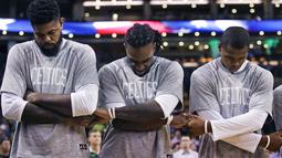 Para pemain Boston Celtics,  Amir Johnson, Jae Crowder, Gerald Green berpegangan tangan saat lagu kebangsaan dikumandangkan sebelum melawan Brooklyn Nets pada laga NBA preseason basketball game, Boston, Selasa (18/10/2016) WIB. (AP/Charles Krupa)