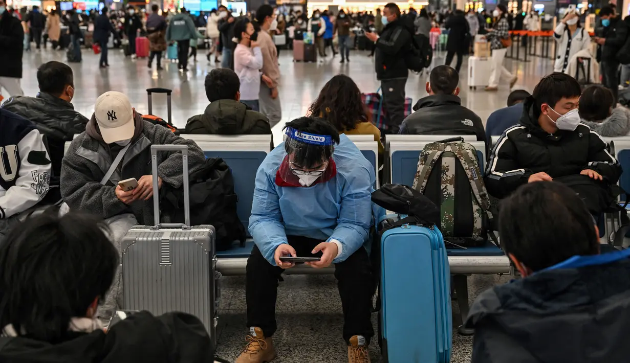 Calon penumpang menunggu kereta di Stasiun Hongqiao, Shanghai China, 11 Januari 2023. Migrasi tahunan di China dimulai dengan orang-orang kembali ke kampung halaman mereka untuk merayakan Tahun Baru Imlek. (Hector RETAMAL/AFP)