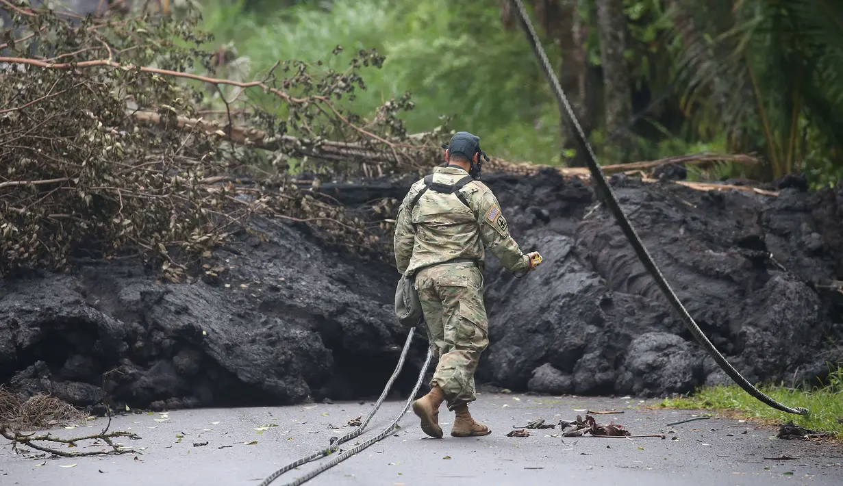 Garda Nasional Angkatan Darat AS memeriksa lahar dingin setelah letusan yang terjadi pada gunung berapi Kilauea di Hawaii (8/5). Usai letusan gunung berapi tersebut lahar dingin memenuhi jalan dan memutus lalu lintas. (Mario Tama / Getty Images / AFP)