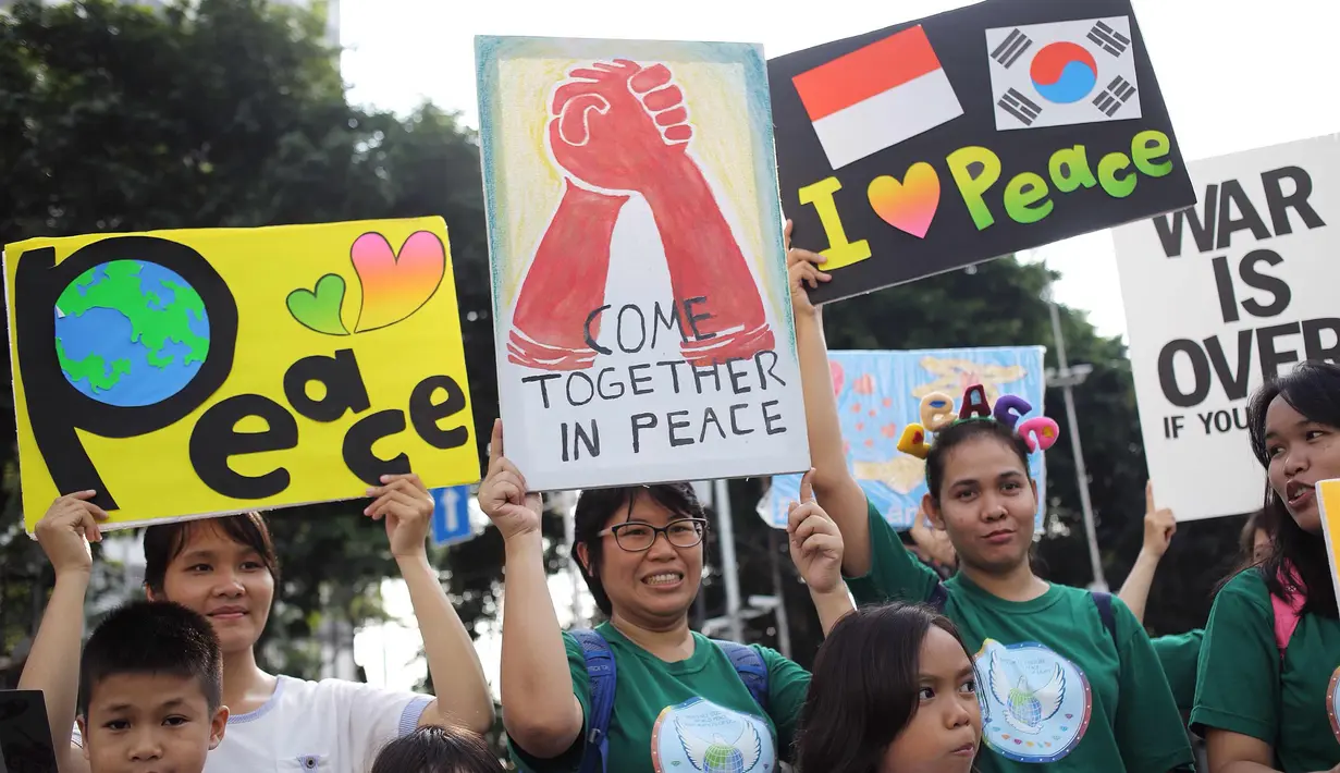 Warga menunjukkan poster saat melakukan kampanye tentang perdamaian dunia saat car free day di kawasan Bunderan HI, Jakarta, Minggu (27/5). Kampanye tersebut bertujuan sebagai seruan untuk menghentikan peperangan. (Liputan6.com/Faizal Fanani)