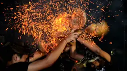 Pemuda Bali menggelar tradisi siat geni atau perang api di Pura Dalam, Tuban, Senin (28/9/2015) malam. Ritual ini diselenggarakan setiap tahun untuk melestarikan tradisi sekaligus memohon keselamatan dan menolak bala. (AFP/Sonny Tumbelaka)