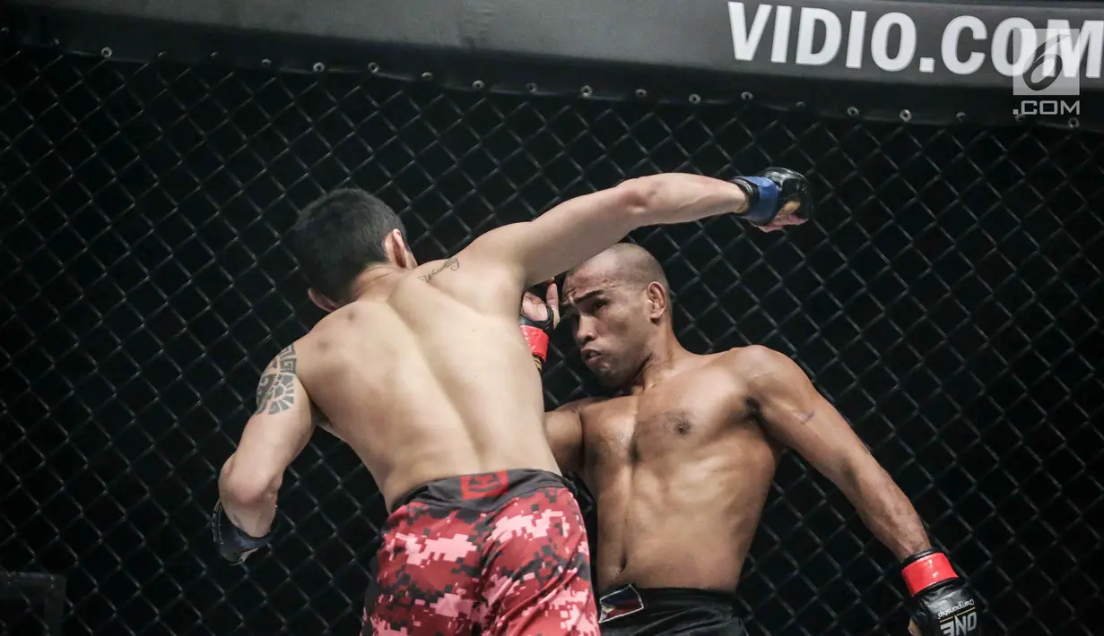 Petarung China, Peng Xue Wen (kiri) melakukan pukulan ke petarung Filipina, Rene Catalan (kanan) saat berlaga pada One Championship di Jakarta, Sabtu (20/1). Petarung Rene Catalan menang atas Peng Xue Wen. (Liputan6.com/Faizal Fanani)