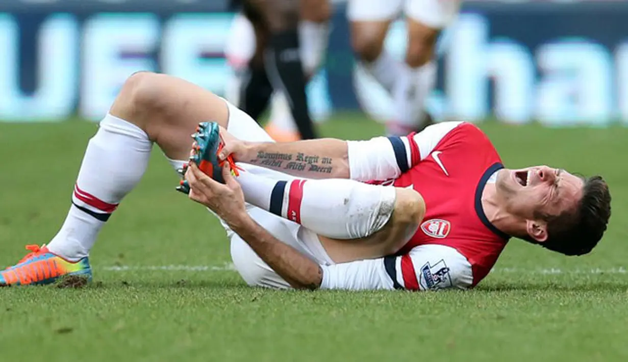 Striker Arsenal Olivier Giroud menahan rasa sakit cedera yang dialaminya pada pertandingan sepak bola Liga Inggris antara Newcastle United vs Arsenal di St James 'Park, Newcastle (30/12/13). (AFP/Ian Manicol)