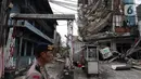 Polisi mengamankan sekitar gedung yang ambruk di Jalan Brigjen Katamso, Kota Bambu Selatan, Palmerah, Jakarta Barat, Senin (6/1/2020). Tiga orang dilaporkan terluka akibat tertima material gedung empat lantai tersebut. (Liputan6.com/Johan Tallo)