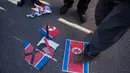 Bendera Korut diinjak pengunjuk rasa anti-Korea Utara saat menggelar aksi di pelabuhan Mukho di Donghae, Korsel (6/2). Mereka melakukan aksi menyambut rombongan seni dari Korut yang akan tampil di Olimpiade Musim Dingin Pyeongchang 2018. (AFP/Ed Jones)
