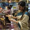 Pekerja melayani seorang perempuan yang berbelanja perhiasan emas pada hari Akshay Tritiya yang dianggap menguntungkan untuk membeli emas di Mumbai, India, Selasa (3/5/2022). Membeli emas adalah kegiatan yang populer di Akshaya Tritiya, karena ini adalah simbol utama kekayaan dan kemakmuran. (AP Photo/Rajanish kakade)&nbsp;