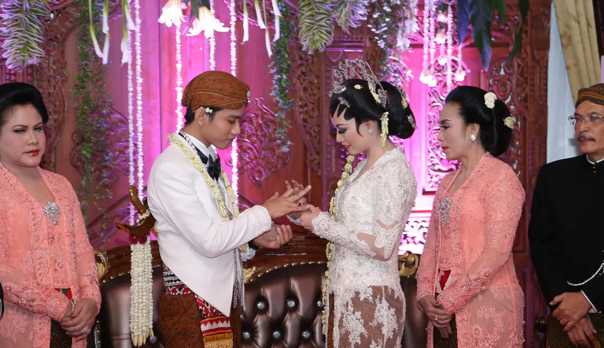 Selvi Ananda sedang memakaikan cincin ke jari Gibran Rakabuming. (Galih W. Satria/Bintang.com)