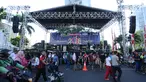 Warga berjalan di depan panggung utama perayaan malam pergantian tahun di kawasan Bundaran Hotel Indonesia, Jakarta, Minggu (31/12). Pemprov DKI Jakarta mendirikan panggung hiburan pergantian tahun di sejumlah titik. (Liputan6.com/Helmi Fithriansyah)