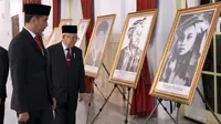 Presiden Joko Widodo (kiri) dan Wakil Presiden Ma'ruf Amin (kanan) melihat-lihat foto Pahlawan Nasional di Istana Negara, Jakarta, Jumat (8/11/2019). Jokowi menganugerahkan gelar Pahlawan Nasional kepada 6 tokoh yang dianggap berjasa untuk Indonesia. (Foto: Lukas-Biro Pers Sekretariat Presiden)