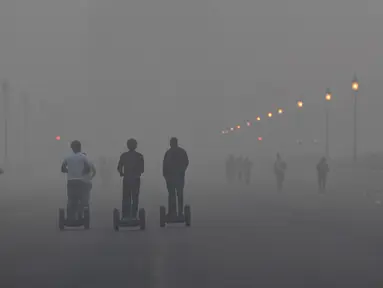 Pejalan kaki menyusuri jalan di tengah kondisi kabut asap tebal di New Delhi (2/11). Tingkat kabut melonjak selama musim dingin di Delhi, ketika kualitas udara melampaui tingkat aman Organisasi Kesehatan Dunia. (AP Photo/Money Sharma)