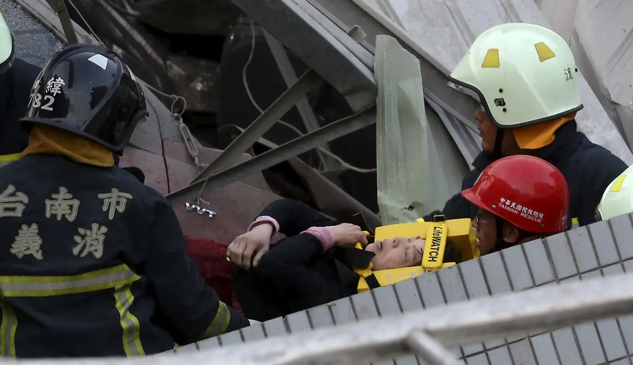 Petugas penyelamat mengevakuasi seorang korban di gedung apertemen yang runtuh akibat gempa 6,4 SR  di Tainan, (6/2). Menurut data meteorologi gempa terjadi pada kedalaman 16,7 kilometer di bawah permukaan laut. (REUTERS/Stringer)