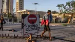 Seorang wanita menutupi wajahnya ketika sisa-sisa gas air mata terasa di udara saat berjalan melewati gedung Parlemen Kenya di pusat kota Nairobi, pada 26 Juni 2024. (LUIS TATO/AFP)