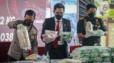 Karo Penmas Mabes Polri Brigjen Pol Rusdi Hartono (kiri) dan Dirtipid Narkoba Bareskrim Polri Brigjen Krisno Halomoan Siregar (tengah) menunjukkan barang bukti terkait penyelundupan narkoba jaringan Malaysia di Gedung Bareskrim Mabes Polri, Jakarta, Selasa (30/3/2021). (Liputan6.com/Faizal Fanani)