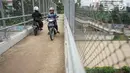 Pengendara sepeda motor melintasi JPO yang melintang di atas Tol Cijago Seksi II di Depok, Jawa Barat, Rabu (15/5). Meskipun berbahaya, namun curamnya akses JPO tidak menjadi penghalang bagi sebagian pemotor untuk menyeberang agar dapat memersingkat waktu tempuh. (Liputan6.com/immanuel Antonius)