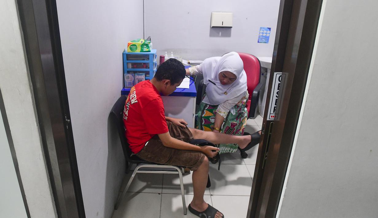 Kelengkapan fasilitas dan kualitas layanan di Puskesmas Kebayoran Lama mendapat perhatian khusus saat Gubernur DKI Jakarta Pramono Anung melakukan kunjungan. Tampak dalam foto, salah satu tenaga medis sedang melakukan pemeriksaan kesehatan warga di Puskesmas Kebayoran Lama, Jakarta, Jumat (9/1/2026). (merdeka.com/Arie Basuki)