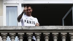 Bintang sepak bola Argentina, Lionel Messi melambai kepada fans dari balkon hotel Royal Monceau di Paris pada Selasa (10/8/2021). Mantan bintang Barcelona itu tiba di hotel setelah menjalani tes medis dan sempat ke Stadion Parc des Princes, kandang PSG (Paris Saint-Germain). (DOUMY / AFP)