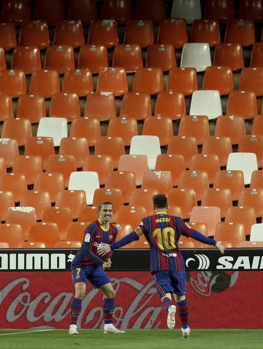Penyerang Barcelona, Antoine Griezmann berselebrasi dengan rekannya Lionel Messi usai mencetak gol ke gawang Valencia pada pertandingan La Liga Spanyol di stadion Mestalla, Senin (3/5/2021). Barcelona menang tipis atas Valencia 3-2. (AP Photo/Alberto Saiz)