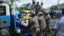 Petugas Dishub DKI dibantu Satpol PP mengangkut motor yang parkir di bahu jalan kawasan Kebayoran Lama, Jakarta, Kamis (12/5). Razia dilakukan untuk membuat jera pengendara yang memarkir kendaraan bukan pada tempatnya (Liputan6.com/Gempur M Surya)