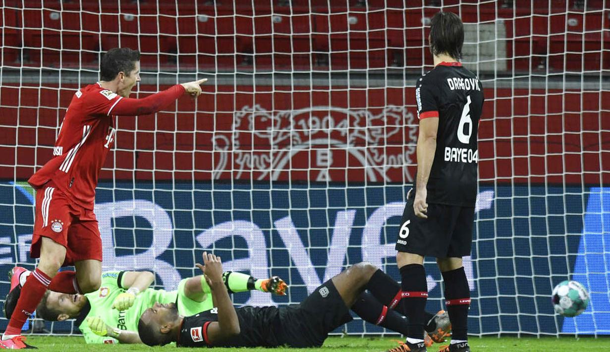 Striker Bayern Munchen, Robert Lewandowski, mencetak gol ke gawang Bayer Leverkusen pada laga Bundesliga di Stadion BayArena, Minggu (20/12/2020). Bayern Munchen menang dengan skor 2-1. (Bernd Thissen/Pool Photo via AP)