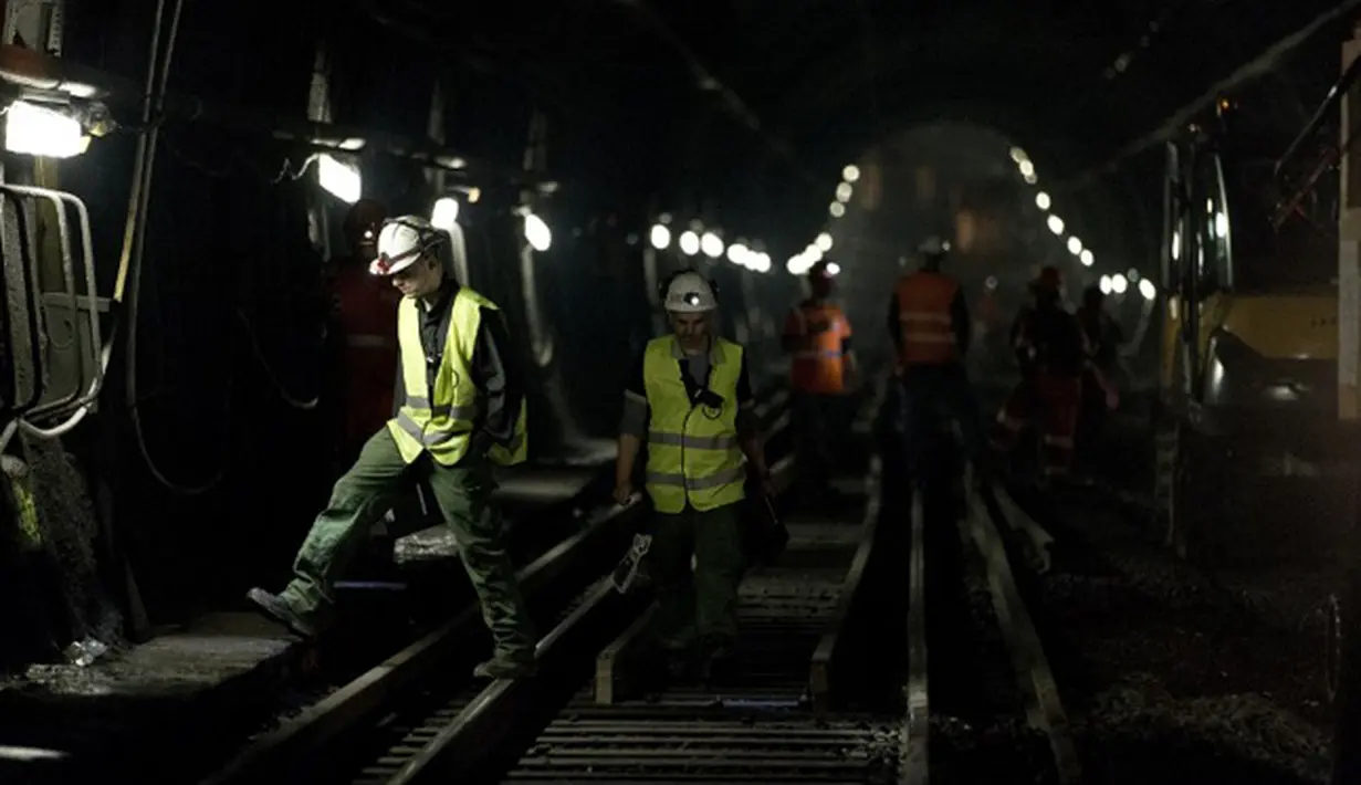 Sejumlah pekerja berjalan di rel saat pembuatan terowongan dan jalur baru kereta api antara Stasiun Charles de Gaulle-Etoile dan Auber, Paris (28/7/2015). Stasiun Charles de Gaulle-Etoile dibuka pada tanggal 1 September 1900. (AFP/KENZO TRIBOUILLARD)