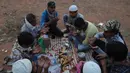Buruh migran dari Uttar Pradesh berdoa sebelum berbuka puasa selama bulan Ramadan, saat bepergian untuk kembali ke negara asal mereka, selama lockdown untuk mencegah penyebaran Covid-19 di pinggiran Hyderabad, India, Selasa, (12/5/2020). (AP Photo/Mahesh Kumar A)