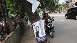 Sejumlah Alat Paraga Kampanye masih terlihat di pinggir Jalan Raya Pasar Minggu, Jakarta, Minggu (14/4). Memasuki masa tenang jelang pelaksanaan Pemilu 2019, sejumlah Alat Paraga Kampanye masih terlihat bertebaran di beberapa ruas jalan. (Liputan6.com/Helmi Fithriansyah)