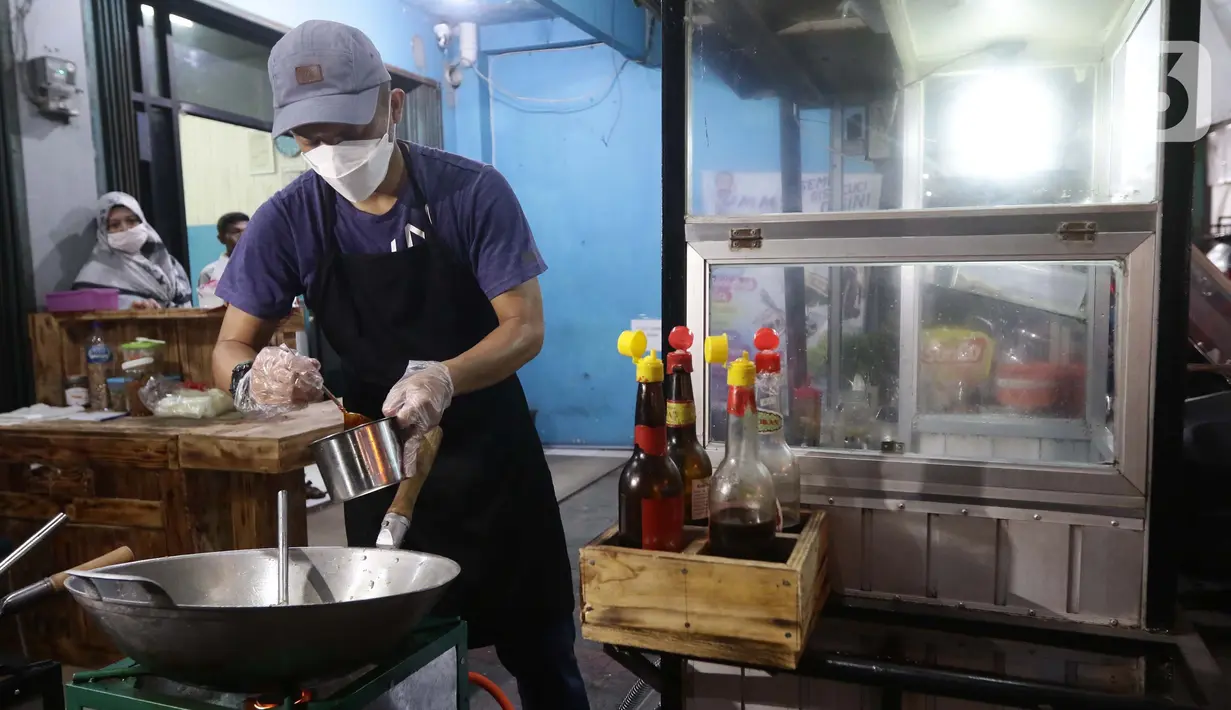 Mantan pegawai fungsional Biro Hukum KPK, Juliandi Tigor Simanjuntak memasak nasi goreng pesanan pelanggan di Jalan Raya Hankam, Bekasi, Rabu (13/10/2021). Tigor berjualan nasi goreng setelah dipecat KPK bersama 57 rekannya yang tidak lolos tes wawasan kebangsaan. (Liputan6.com/Helmi Fithriansyah)