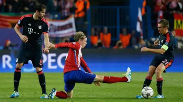 Penyerang Atletico Madrid, Fernando Torres (tengah) berusaha merebut bola yang dibawa bek Bayern Muenchen, Philipp Lahm di leg pertama liga champions di Vicente Calderon, Madrid, (28/4). Atletico menang atas Muenchen dengan skor 1-0. (Reuters/Paul Hanna)