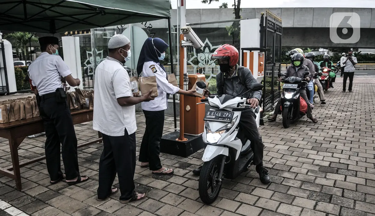 Petugas membagikan takjil kepada pengendara secara drive thru di Kompleks Masjid Al-Azhar, Jakarta, Selasa (13/4/2021). Pengelola Masjid Al-Azhar menyiapkan 500 bungkus takjil per hari yang dibagikan secara drive thru guna mencegah penyebaran COVID-19. (merdeka.com/Iqbal S. Nugroho)