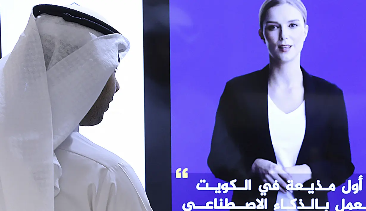 Seorang jurnalis menonton video perkenalan pembawa berita kecerdasan buatan (AI) Fedha di akun twitter layanan Kuwait News, di Kuwait City pada 9 April 2023. (Photo by YASSER AL-ZAYYAT / AFP)