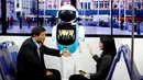 Pengunjung berbincang di depan robot simulasi angkutan umum di Konferensi Robot Dunia WRC 2016 di Beijing, Tiongkok (21/10). Pameran robot kelas dunia ini berlangsung dari 21 - 25 Oktober. (Reuters/Thomas Peter)