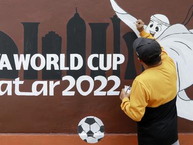 Warga menyelesaikan pembuatan mural bertema Piala Dunia 2022 di Perum Depok Maharaja Blok M1 Cluster Cemara, Rangkapan Jaya, Depok, Jawa Barat, Minggu (30/10/2022). (Bola.com/M Iqbal Ichsan)