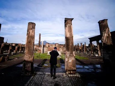 Seorang wisatawan melihat Sanctuary of Apollo, Pompeii, Italia, Senin (25/11/2019). Pompeii adalah kota zaman Romawi Kuno yang hancur oleh letusan Gunung Vesuvius pada 79 M. (Filippo MONTEFORTE/AFP)