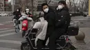 Pengendara skuter dengan masker melintasi persimpangan di Beijing, China, Jumat (2/12/2022). Lebih banyak kota melonggarkan pembatasan, memungkinkan pusat perbelanjaan, supermarket, dan bisnis lainnya dibuka kembali menyusul protes akhir pekan lalu di Shanghai dan daerah lain di mana beberapa orang menyerukan Presiden Xi Jinping untuk mengundurkan diri. (AP Photo/Ng Han Guan)