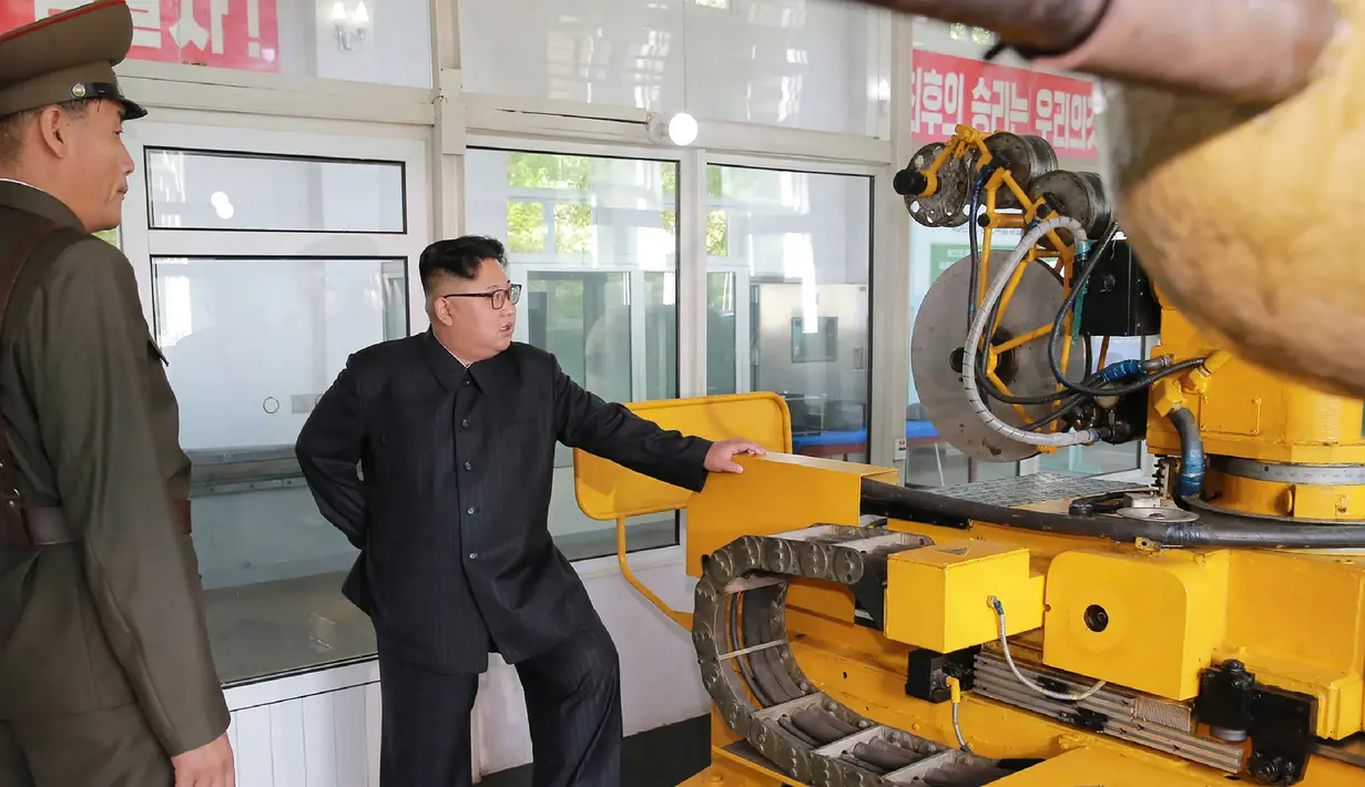 Pemimpin Korea Utara, Kim Jong-Un saat melakukan kunjungan ke institut material kimia di Akademi Ilmu Pertahanan pada tanggal 23 Agustus 2017. Kim Jong-Un juga ditunjukkan mesin roket dengan bahan bakar padat.  (AFP Photo/Kcna Via Kns/Str)
