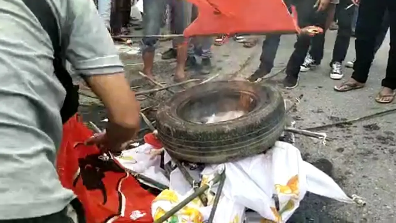 massa demonsrasi membakar bendera PDIP di Kendari saat kedatangan Jokowi, Rabu (30/6/2021)