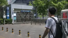 Seorang pria yang mengenakan masker melihat ke pintu keluar stasiun kereta bawah tanah yang tertutup di Beijing, China Rabu (4/5/2022). Beijing pada hari Rabu ini menutup lebih dari 40 stasiun kereta bawah tanah, sekitar sepersepuluh dari jaringan kereta, sebagai bagian dari tindakan untuk menghentikan penyebaran Covid-19. (AP Photo/Mark Schiefelbein)